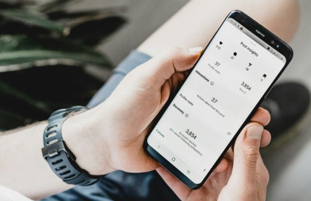 Man checking social media analytics and performance data on a mobile phone