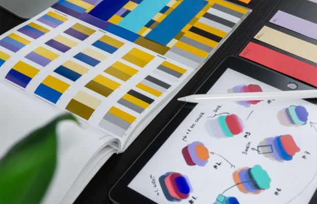 Custom logo colour variations displayed on iPad with design swatch books