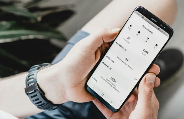 Man checking social media analytics and performance data on a mobile phone
