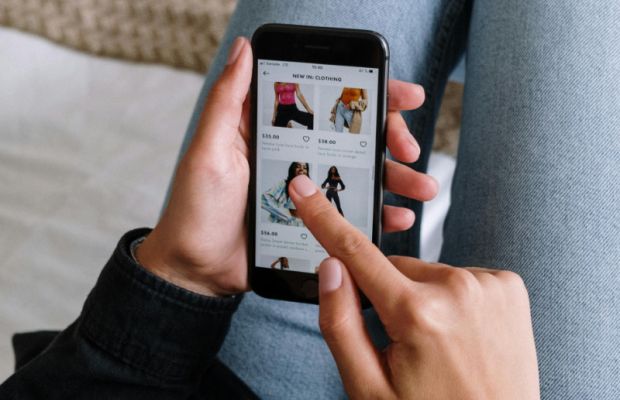 Person browsing an online store on a mobile phone, highlighting mobile-friendly e-commerce design