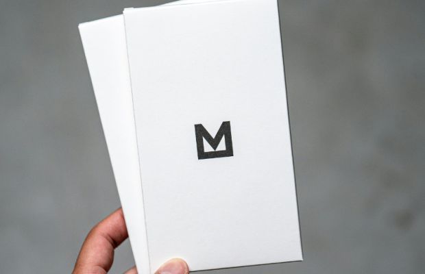 Printed logo design held up for review, showcasing scalability across formats