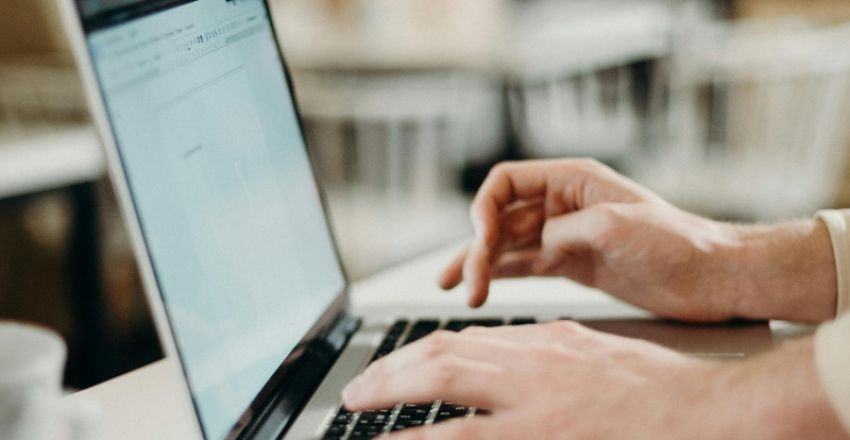 Person working on a laptop to create an email marketing campaign
