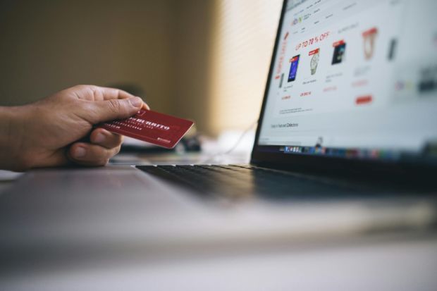 Person making an online purchase on a computer using a credit card
